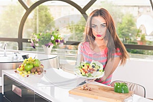 Attractive young woman holding fresh vegetable salad