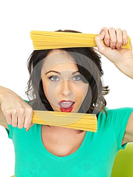 Attractive Young Woman Holding Handfulls of Dried Spaghetti Pasta