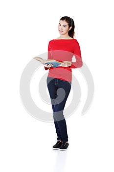 Attractive young woman holding open book,reading.