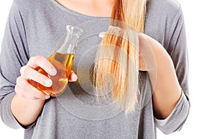 Attractive young woman holding scented oil bottle