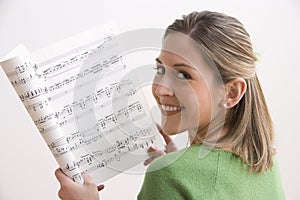 Attractive Young Woman Holding Sheet Music