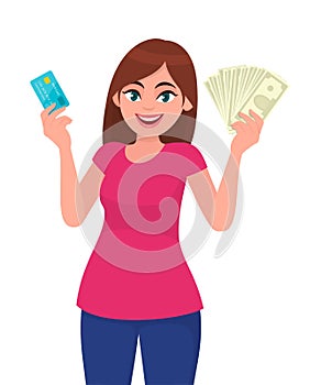 Attractive young woman holding or showing a credit/debit card and cash/money/currency notes in hand. Wireless modern bank payment.