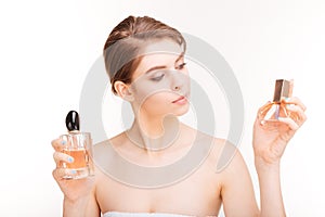 Attractive young woman holding two bottles of parfums