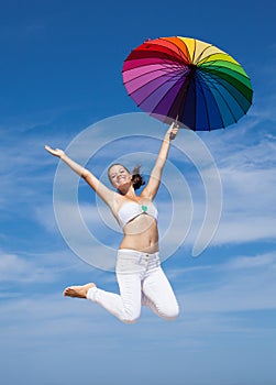 Attractive young woman jumping with parasol