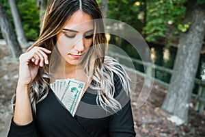 Attractive young woman with lascivious look provokes with money, concept of capitalism against feminism photo
