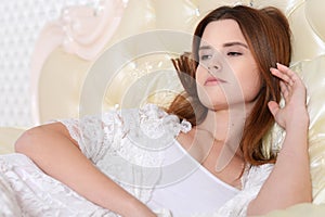 Attractive young woman lying on vintage bed