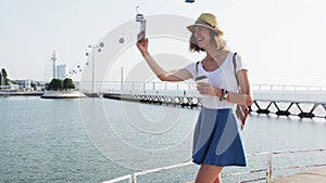 Attractive young woman make photo near Lisbon Oceanarium near river Tagus