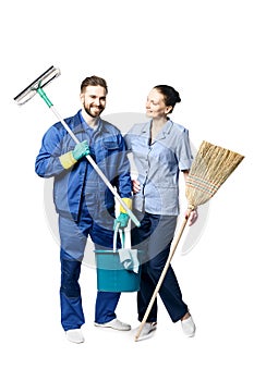 Attractive young woman and man in cleaning uniform and rubber gloves holding a broom cleaning products in his hands, isolated on
