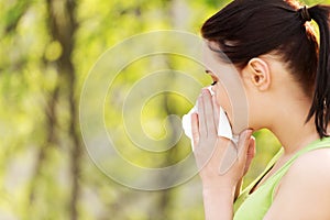 Attractive young woman outdoor with tissue.