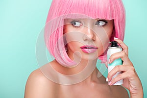 attractive young woman with pink bob cut holding coloring hair spray