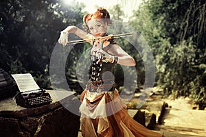 Attractive young woman playing on violin outdoors.