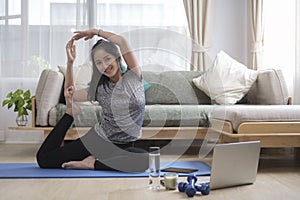 Attractive young woman practicing yoga, king pigeon pose to meditation at home. Healthy lifestyle concept