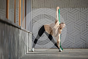 Attractive young woman practicing yoga, performing Trikonasana exercise, triangle pose