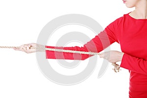 Attractive young woman pulling a rope.