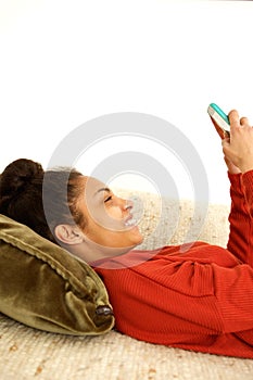 Attractive young woman relaxing at home using cellphone