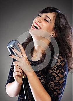 Attractive young woman with a retro microphone