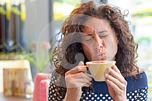 Attractive young woman savoring a cup of coffee