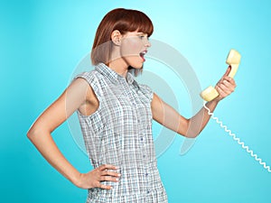 Attractive young woman screaming on the telephone