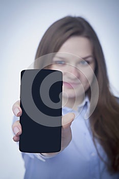 Attractive young woman showing smart phone. Free space for tex and design