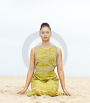 Attractive young woman sitting alone at the beach