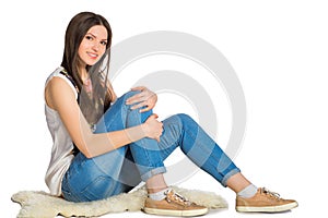 Attractive young woman sitting on floor isolated