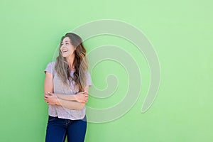 Attractive young woman smiling and looking away on green background