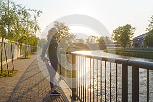 Attractive young woman stretching her legs before her early morning exercise