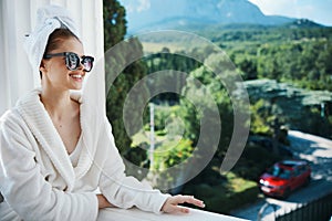 Attractive young woman in sunglasses at the hotel on the balcony Relaxation concept