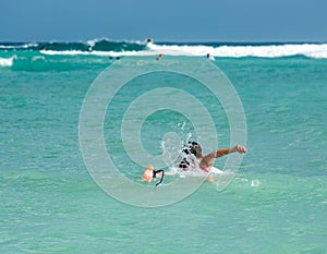 Young woman on surfboard in ocean photo