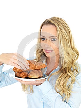 Attractive Young Woman Taking A Croissant From a Plate of Danish Pastries