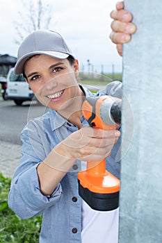 attractive young woman using cordless screwdriver