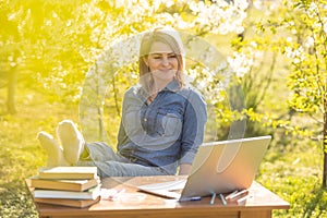 attractive young woman using laptop outside.