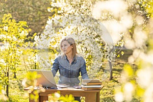 attractive young woman using laptop outside.