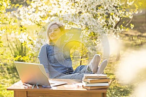 attractive young woman using laptop outside.