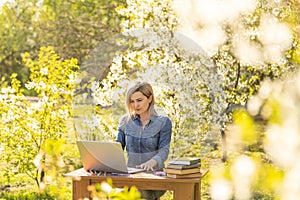attractive young woman using laptop outside.