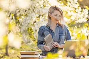 attractive young woman using laptop outside.