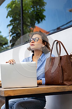 attractive young woman using laptop outside