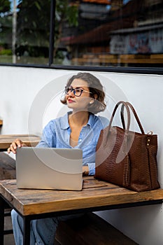 attractive young woman using laptop outside