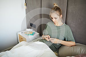 Attractive young woman using smartphone in bed