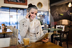 Attractive young woman using tablet in cafe