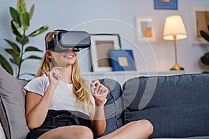 Attractive young woman in VR headset gesturing and smiling