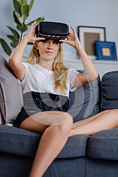 Attractive young woman in VR headset gesturing and smiling