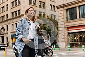 Attractive young woman walking in the city and look with smile away