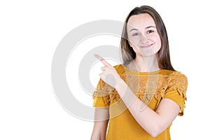 Attractive young woman wearing mustard shirt posing pointing with finger