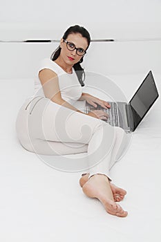 Attractive young woman working on her laptop at home