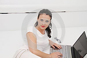 Attractive young woman working on her laptop at home