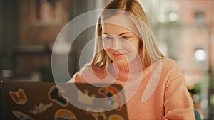 Attractive Young Woman Working on Laptop Computer while Sitting in Stylish Cozy Creative Office