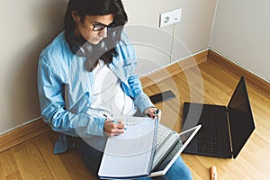 Attractive young woman working with a laptop at home, teleworking concept