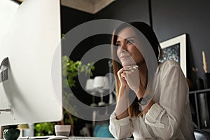 Attractive young woman working at office, using contemporary desktop computer.