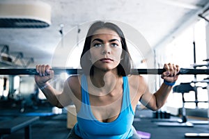 Attractive young woman working out with barbell